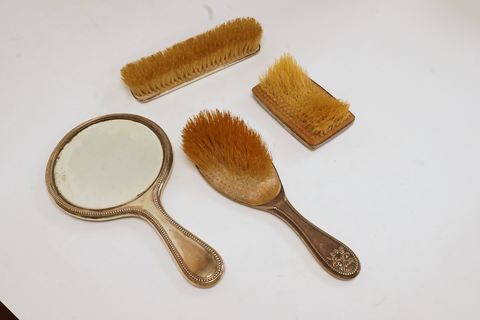 A George V three piece silver mounted three piece mirror and brush set by William Hutton & Sons Ltd and one other silver mounted hair brush. Condition - poor